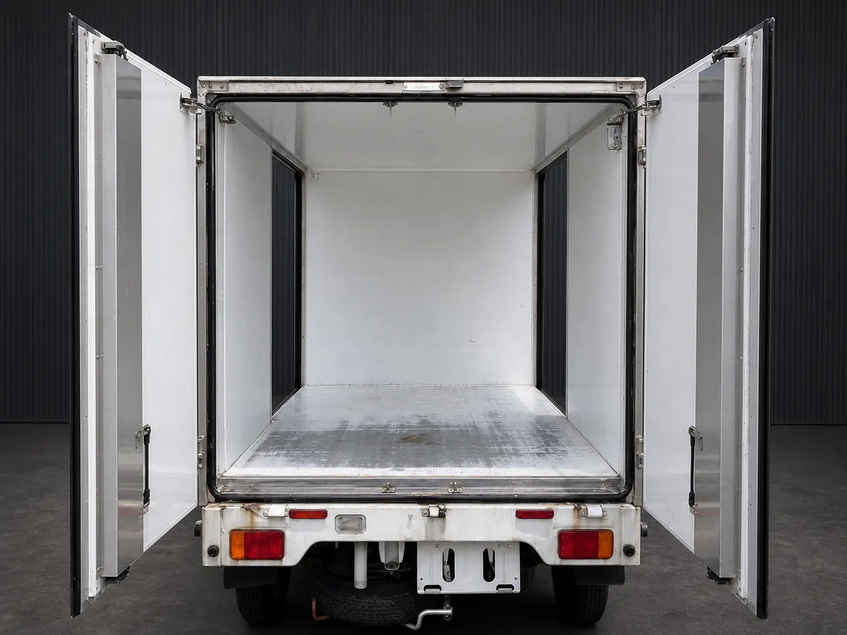 Open rear view into a smooth-panel enclosed cargo box on a kei truck