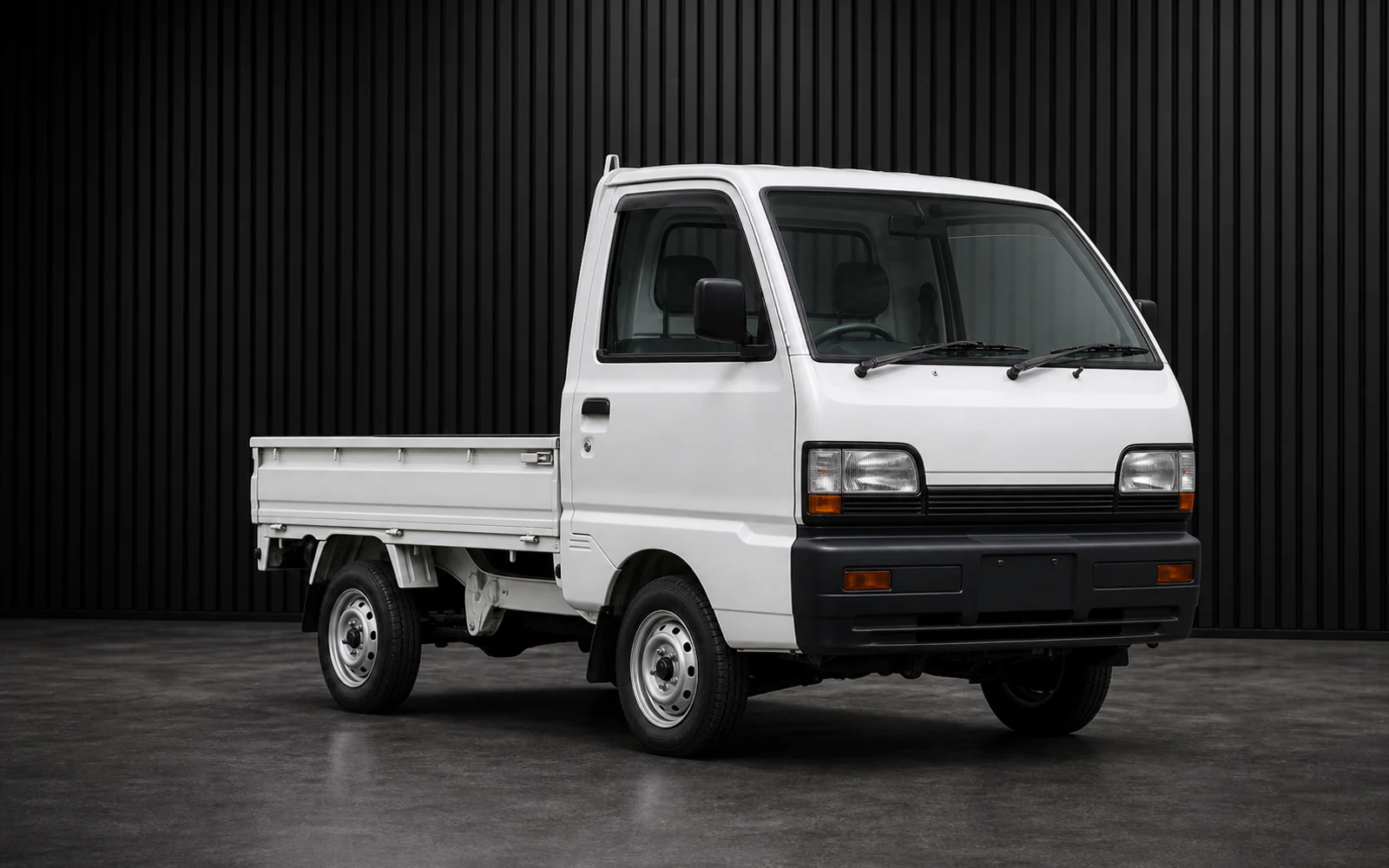 1990s Mitsubishi Minicab U42T-era 4WD kei truck in a dark grooved-wall studio