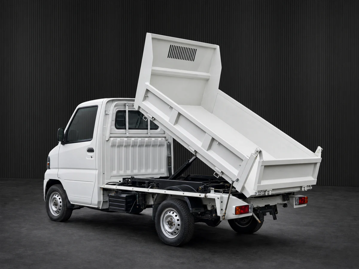Mitsubishi Minicab U62T-era dump kei truck with its bed raised in a dark grooved-wall studio