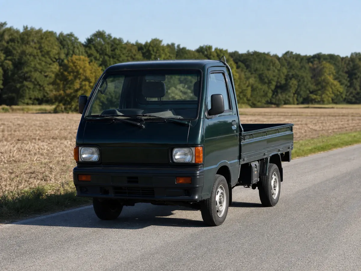 Dark green Japanese kei truck on a quiet American county road