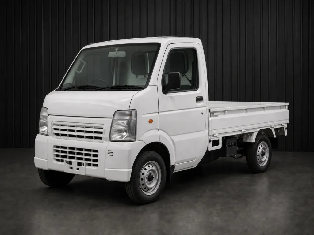 White Suzuki Carry kei truck photographed against a dark grooved wall