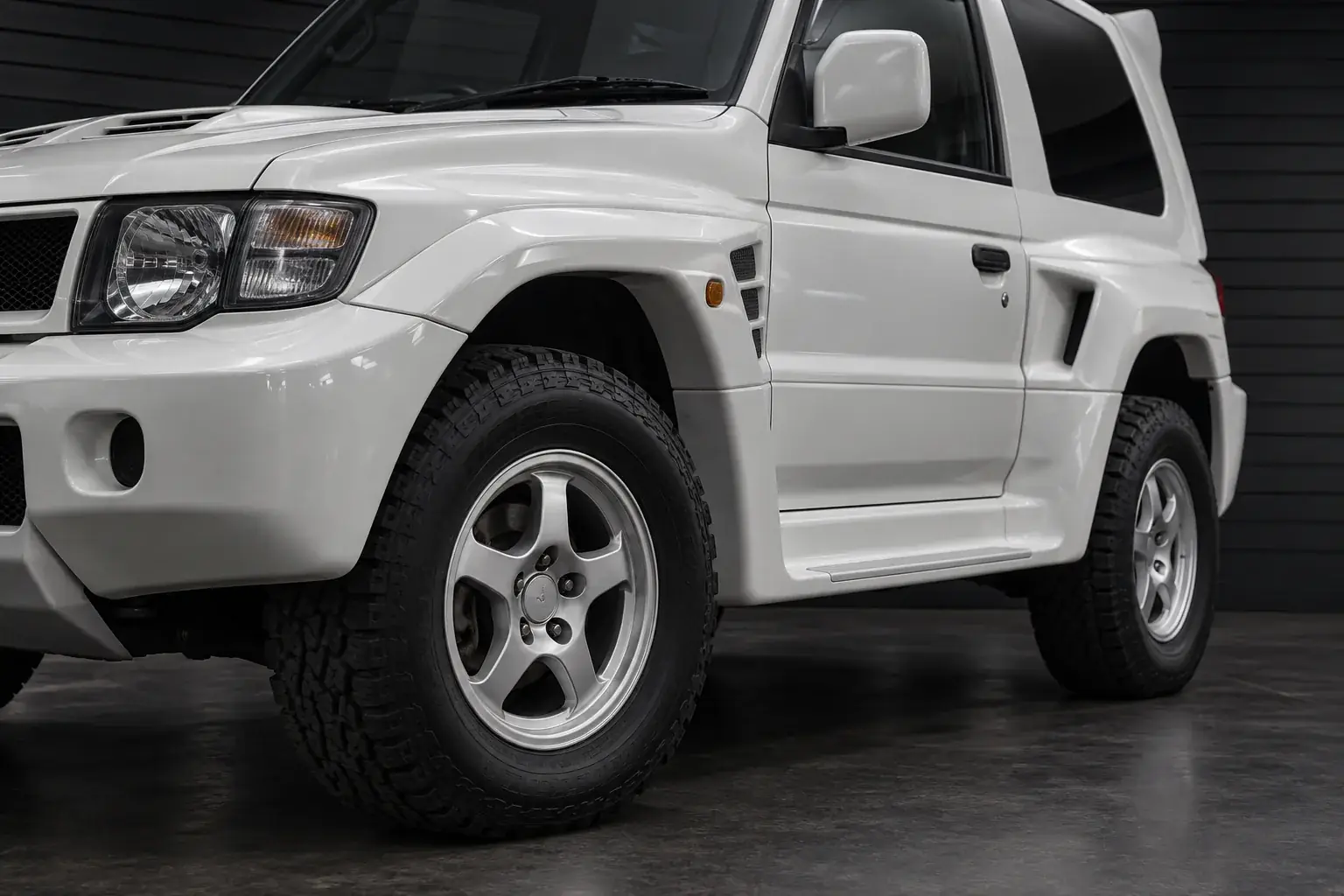 Wide-arch body and specialized exterior hardware detail of a 1990s Japanese rally SUV