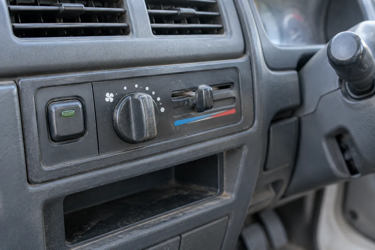 A/C switch, fan knob and temperature slider in an older kei truck